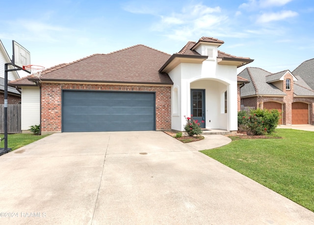 view of front of home with a garage and a front lawn