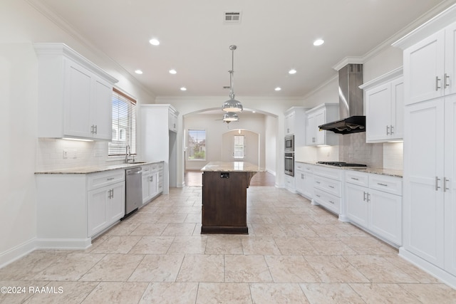 kitchen featuring white cabinetry, a center island, wall chimney exhaust hood, and appliances with stainless steel finishes