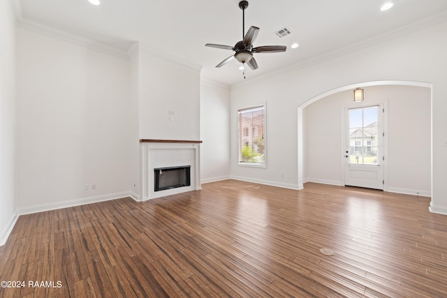 unfurnished living room featuring ceiling fan, wood-type flooring, and ornamental molding