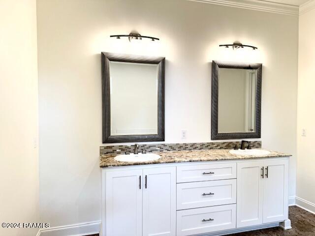 bathroom featuring tasteful backsplash, crown molding, and vanity