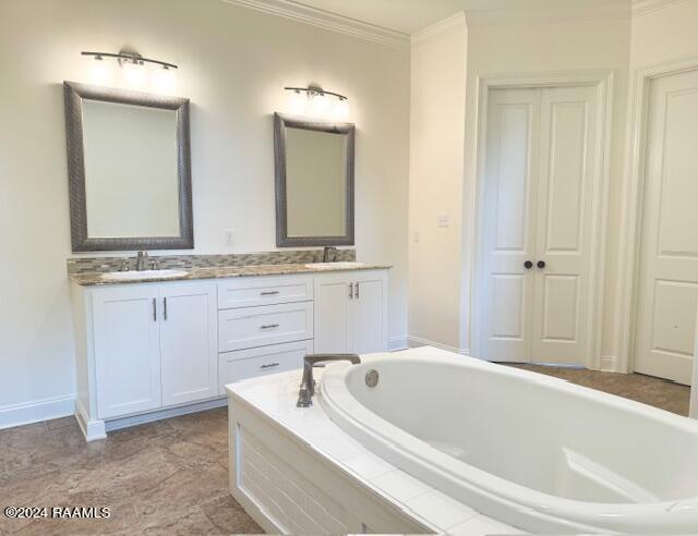 bathroom featuring vanity, crown molding, and tiled tub