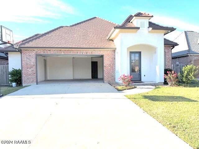 view of front of house featuring a front lawn and a garage