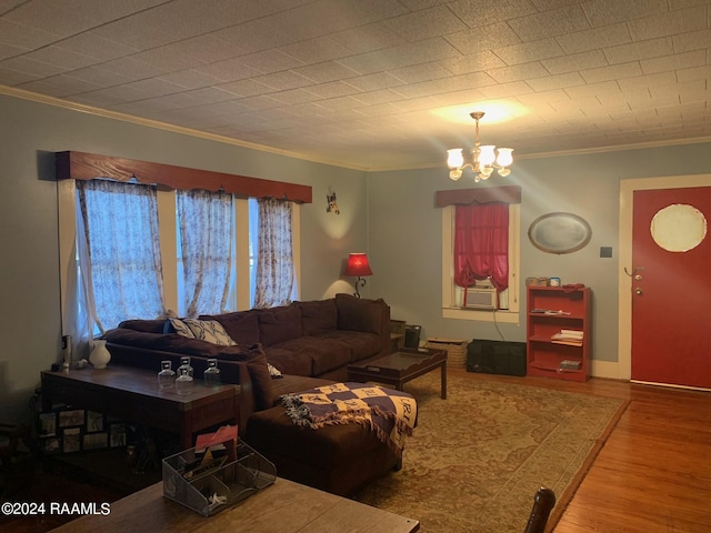 living room with crown molding, an inviting chandelier, and hardwood / wood-style floors