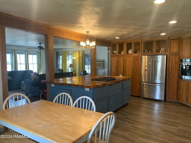 interior space featuring gray cabinetry, ceiling fan with notable chandelier, appliances with stainless steel finishes, a center island, and dark hardwood / wood-style flooring