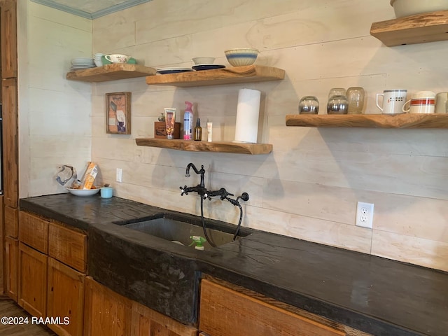 bar featuring tasteful backsplash, ornamental molding, and sink