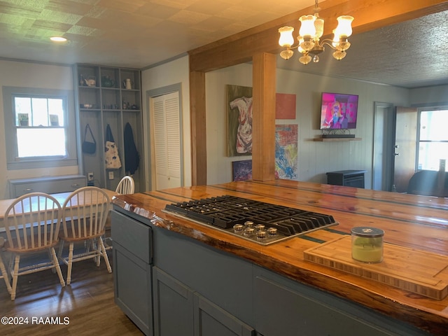 kitchen featuring gray cabinetry, hanging light fixtures, stainless steel gas cooktop, a chandelier, and butcher block counters