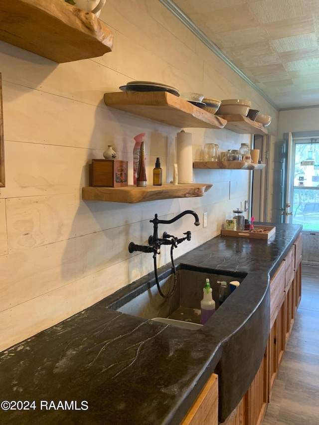 kitchen with dark stone counters, wood-type flooring, and sink