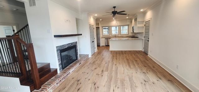 unfurnished living room with a fireplace, ornamental molding, ceiling fan, and light hardwood / wood-style floors