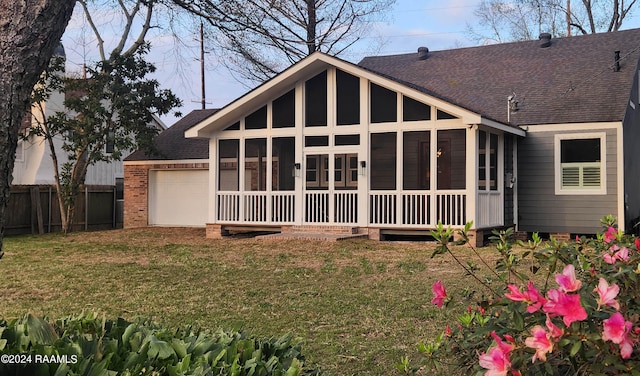 rear view of house with a yard and a sunroom