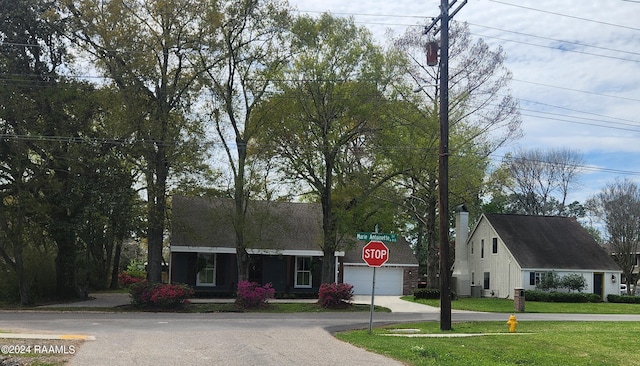 view of front of home with a garage and a front lawn