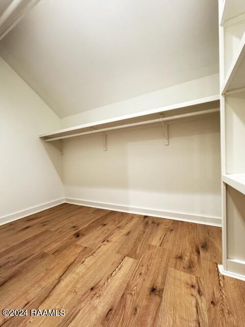 spacious closet featuring lofted ceiling and wood-type flooring