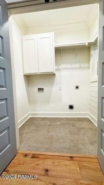 washroom with hookup for a washing machine, cabinets, hookup for an electric dryer, and light hardwood / wood-style floors