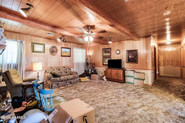 carpeted living room with ceiling fan, wood ceiling, and wood walls