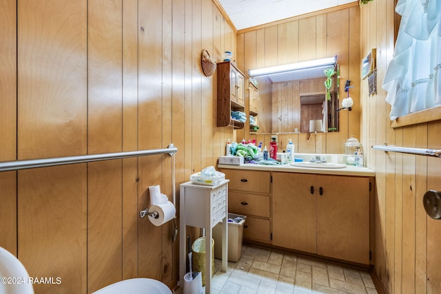 bathroom featuring wood walls, tile flooring, oversized vanity, and toilet