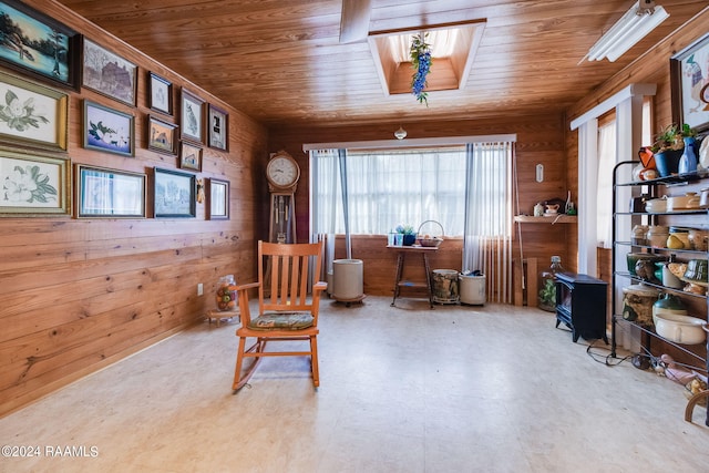 living area featuring wooden walls, a skylight, and wooden ceiling