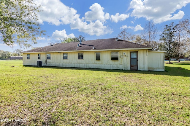 rear view of property featuring a lawn