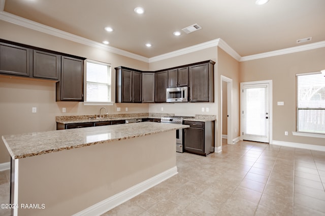 kitchen featuring plenty of natural light, light tile floors, stainless steel appliances, and light stone countertops