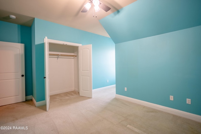 unfurnished bedroom featuring a closet, ceiling fan, vaulted ceiling, and light carpet