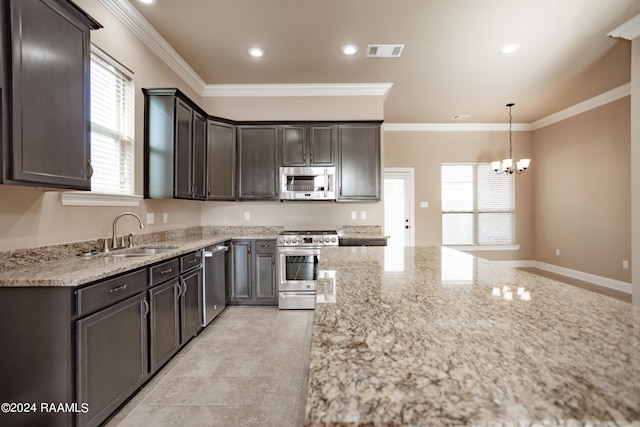 kitchen with appliances with stainless steel finishes, a wealth of natural light, an inviting chandelier, and light stone counters