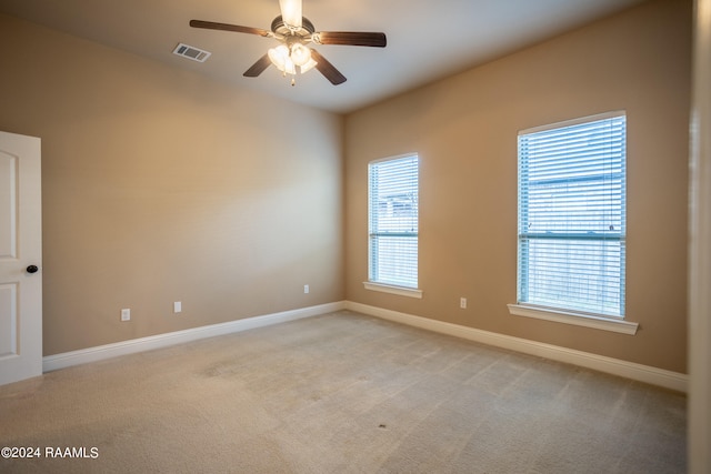 spare room featuring ceiling fan and light carpet