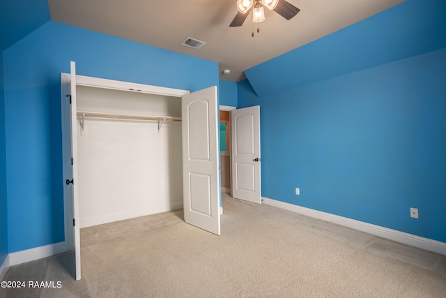 unfurnished bedroom with a closet, light carpet, lofted ceiling, and ceiling fan