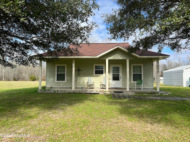 bungalow-style house featuring covered porch and a front lawn