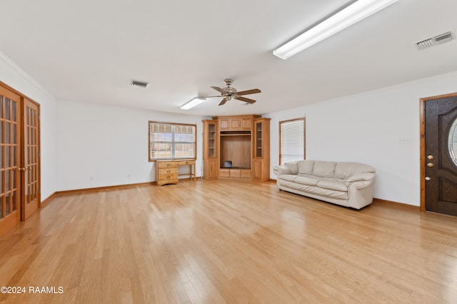 unfurnished living room featuring ceiling fan, crown molding, and light hardwood / wood-style flooring