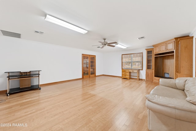 living room with light hardwood / wood-style flooring, ceiling fan, and crown molding