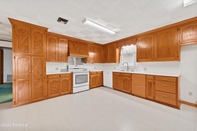 kitchen with custom range hood, sink, white appliances, and light tile floors