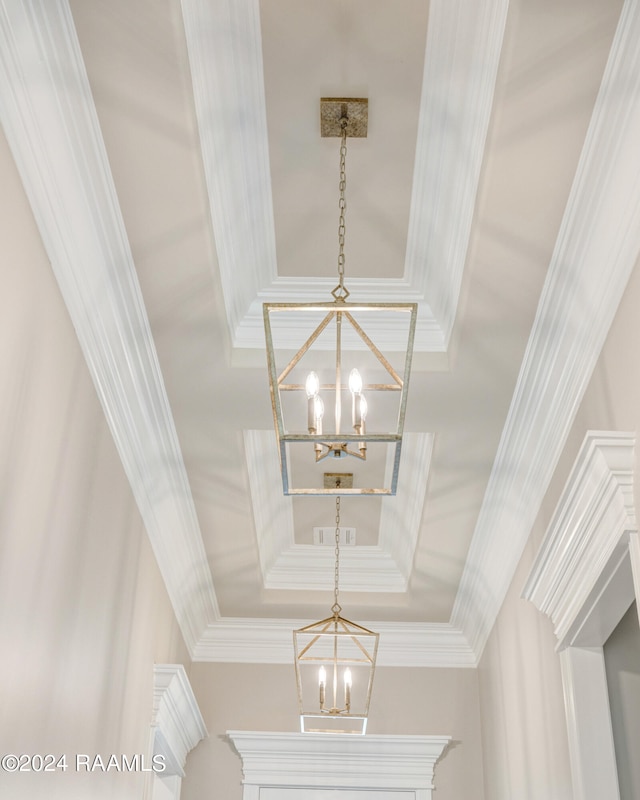 interior details with an inviting chandelier, crown molding, and a raised ceiling