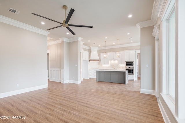 kitchen featuring ceiling fan, a kitchen island with sink, light hardwood / wood-style floors, stainless steel appliances, and white cabinets