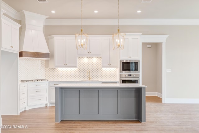 kitchen featuring appliances with stainless steel finishes, white cabinets, light hardwood / wood-style flooring, backsplash, and hanging light fixtures