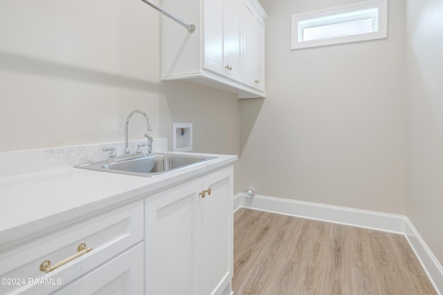 laundry area with cabinets, hookup for a washing machine, sink, and light hardwood / wood-style flooring