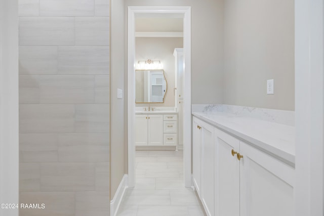 bathroom with tile flooring, ornamental molding, and vanity