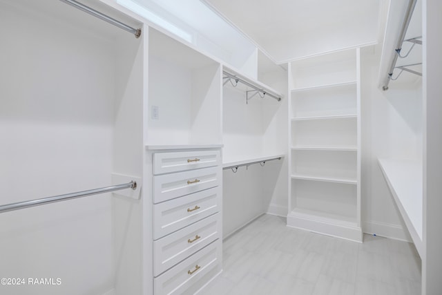 walk in closet featuring light tile floors