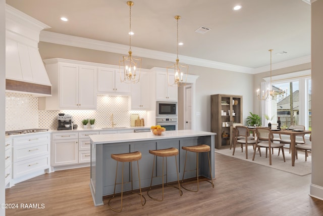 kitchen featuring backsplash, a kitchen island, white cabinetry, and appliances with stainless steel finishes