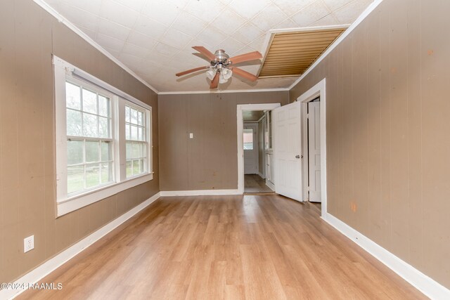 spare room featuring ceiling fan, ornamental molding, and light wood-type flooring