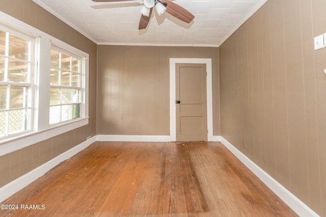 spare room featuring ceiling fan, crown molding, and light wood-type flooring