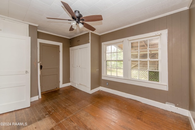 unfurnished bedroom with crown molding, a closet, ceiling fan, and dark hardwood / wood-style flooring