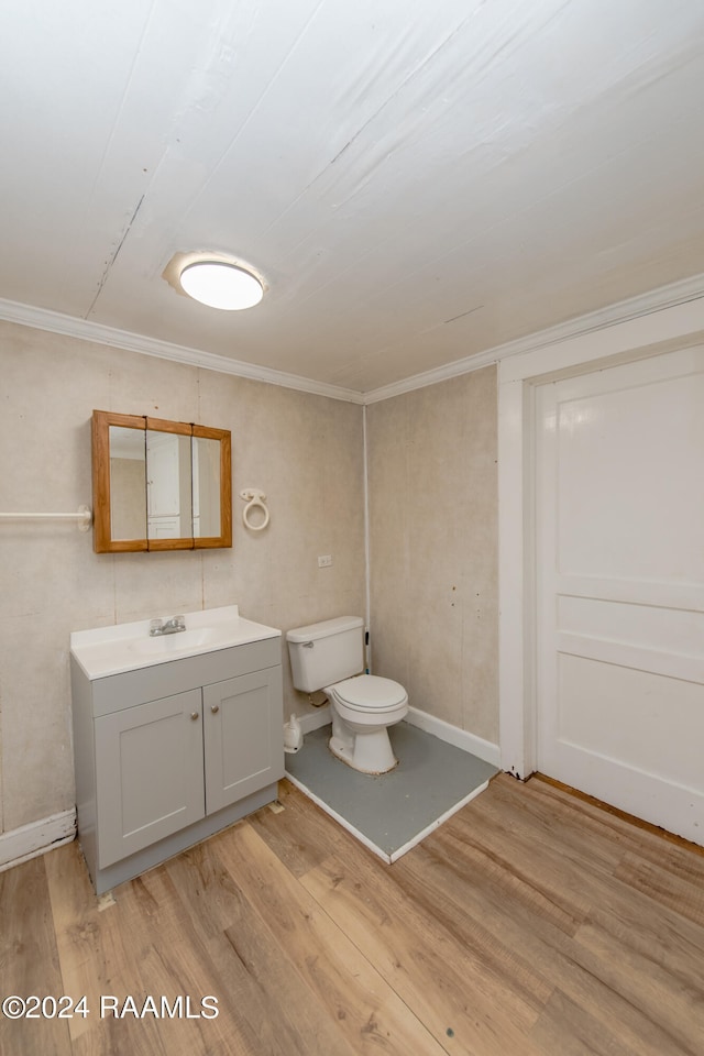 bathroom featuring crown molding, toilet, hardwood / wood-style flooring, and vanity