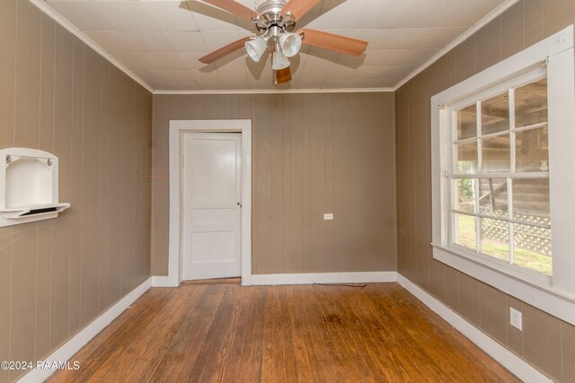 empty room featuring ceiling fan, ornamental molding, and dark hardwood / wood-style floors