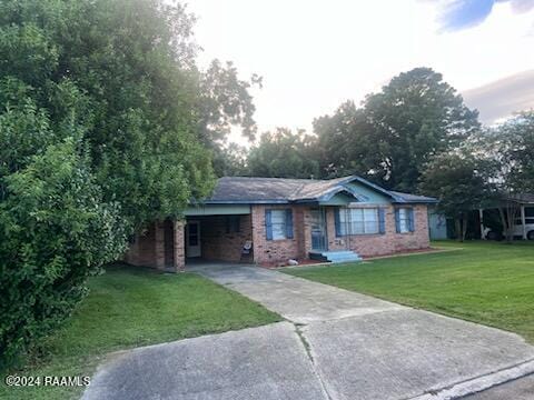 single story home featuring a carport and a front yard