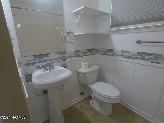 bathroom featuring tile patterned floors, tasteful backsplash, toilet, and sink