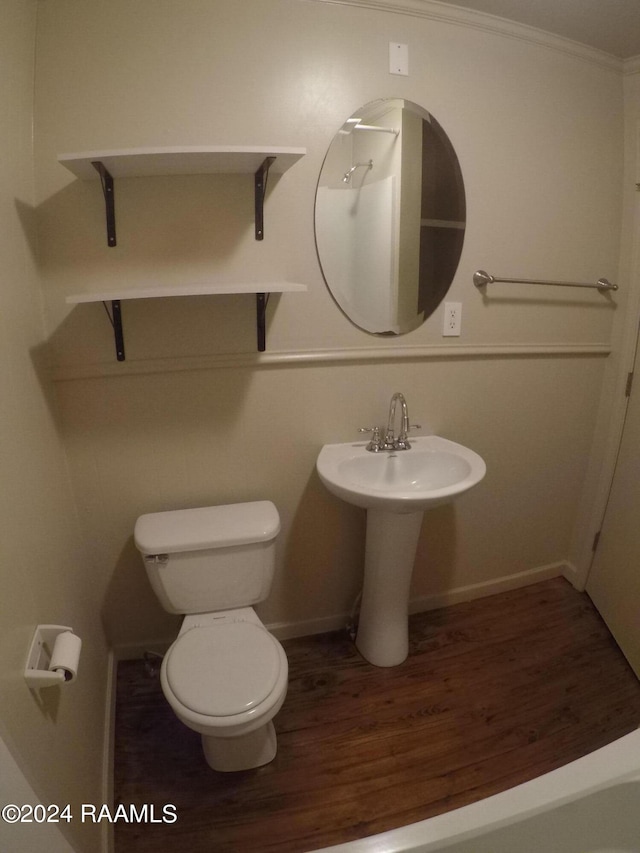 bathroom featuring crown molding, wood-type flooring, and toilet