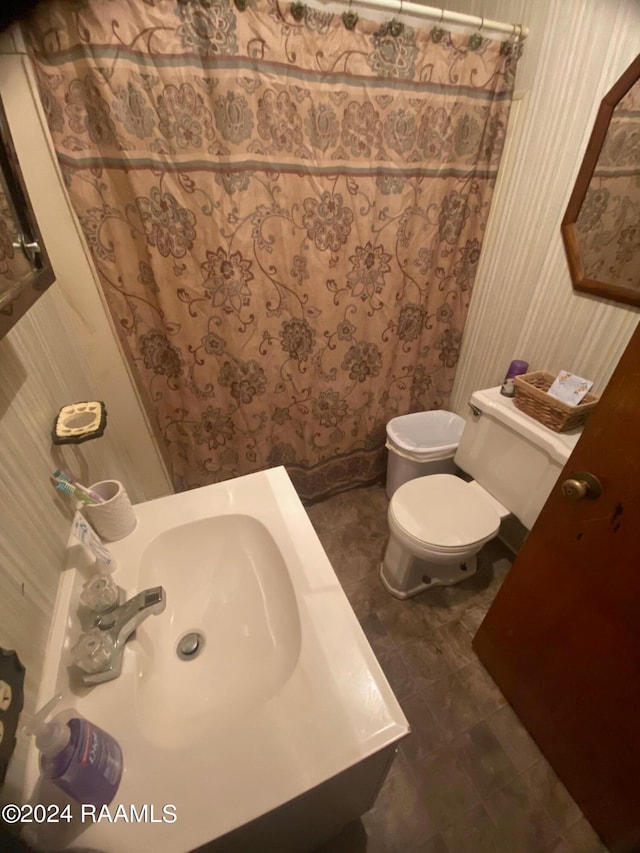 bathroom featuring toilet, tile floors, and sink