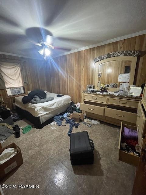 tiled bedroom with wooden walls, ceiling fan, and ornamental molding