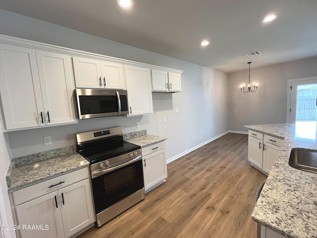 kitchen with recessed lighting, visible vents, light wood-style floors, white cabinets, and appliances with stainless steel finishes