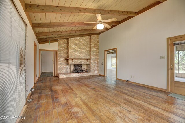 unfurnished living room with a fireplace, beam ceiling, ceiling fan, and light wood-type flooring