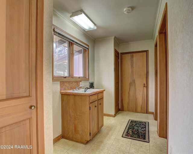 bathroom with tile flooring, ornamental molding, and vanity