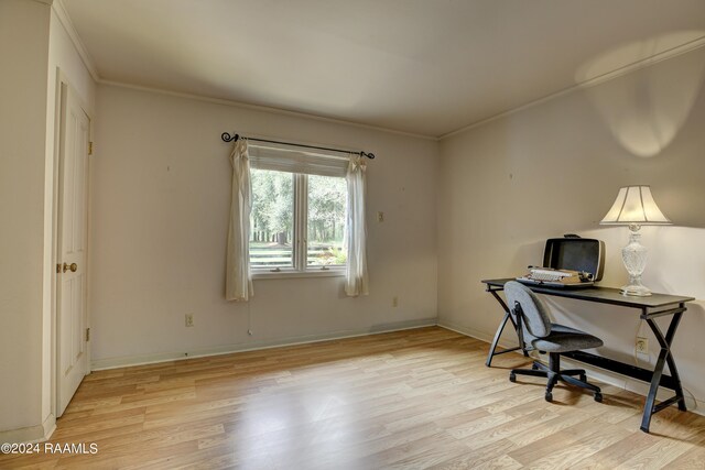 home office with crown molding and light hardwood / wood-style floors